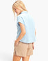 Beach Rose Co. light blue cotton button-up top with rolled sleeves worn by a woman, back view.