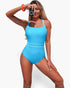 Beach Rose Co. bright blue one-piece swimsuit with cross-back straps worn by a woman holding a vintage camera