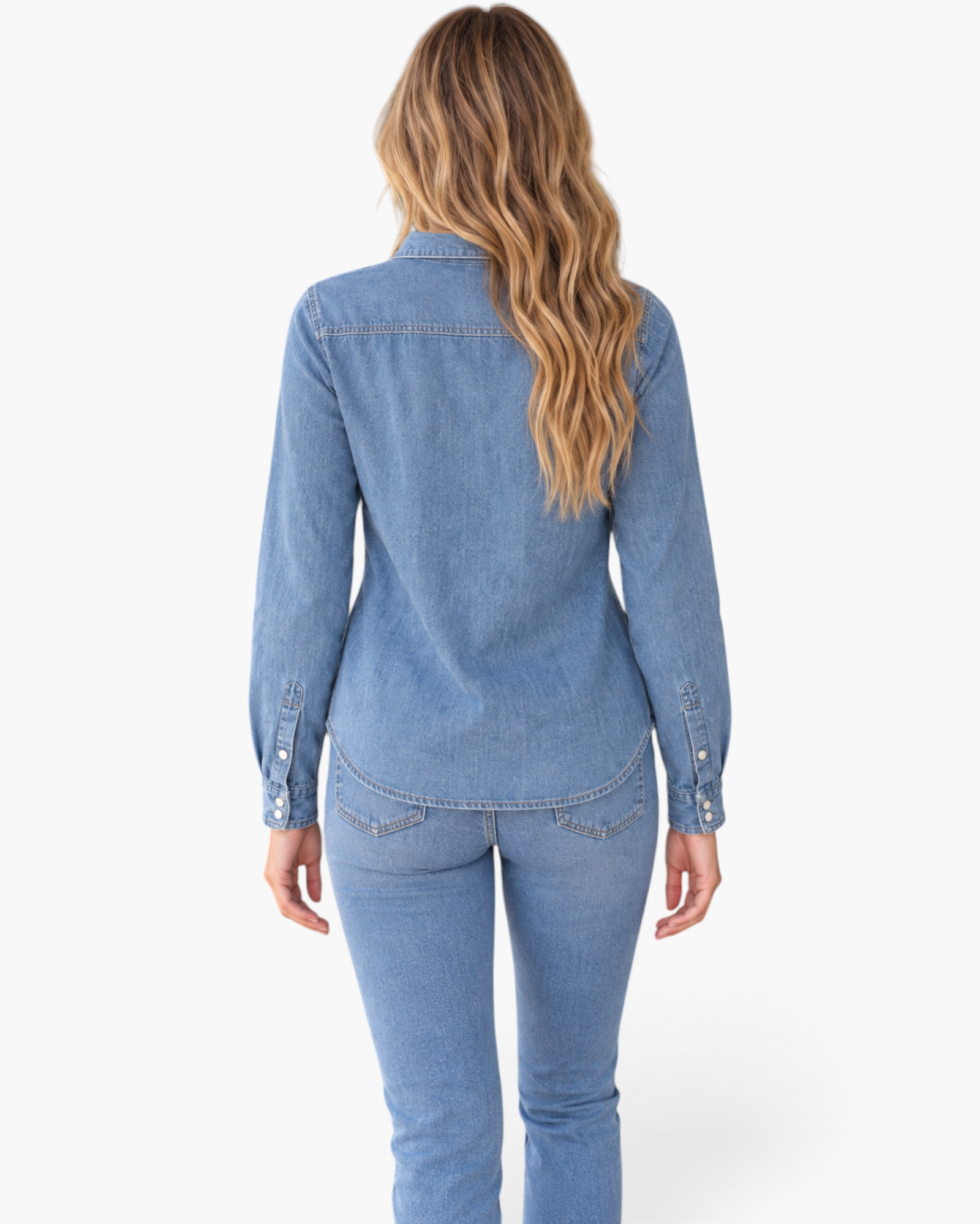Back view of a woman wearing a Beach Rose Co. blue denim shirt with a back yoke and long sleeves, tucked into jeans.