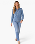 Beach Rose Co. blue denim shirt with white looping embroidery, pointed collar, and snap-front closure on a model.