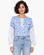 Beach Rose Co. blue floral print long sleeve top with a buttoned placket and contrasting patterned sleeves.