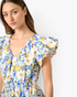 Beach Rose Co. blue floral cotton mini dress with a V-neckline and layered ruffle sleeves on a model