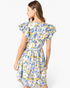 Model wearing a Beach Rose Co. blue floral cotton mini dress with layered ruffle sleeves and a gathered waist