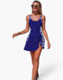 Beach Rose Co. blue one-piece swimsuit with patchwork side panels and adjustable tie-up skirt detail on a model