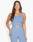 Beach Rose Co. model wearing a light blue ribbed tank top with a form-fitting design and scoop neckline