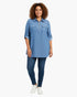 Beach Rose Co. blue zip-front tunic blouse with utility pockets and roll-tab sleeves worn by a curly-haired model.