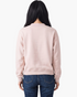 Back view of Beach Rose Co. blush pink mock neck sweatshirt with ribbed hem and cuffs worn by a woman with dark hair.