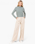 Beach Rose Co. bone corduroy wide-leg pants with elastic-back waist worn by a model with a sage green turtleneck.
