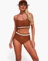 Beach Rose Co. brown two-piece bikini with white contrast trim, adjustable tie-up sides, and matching baseball cap.