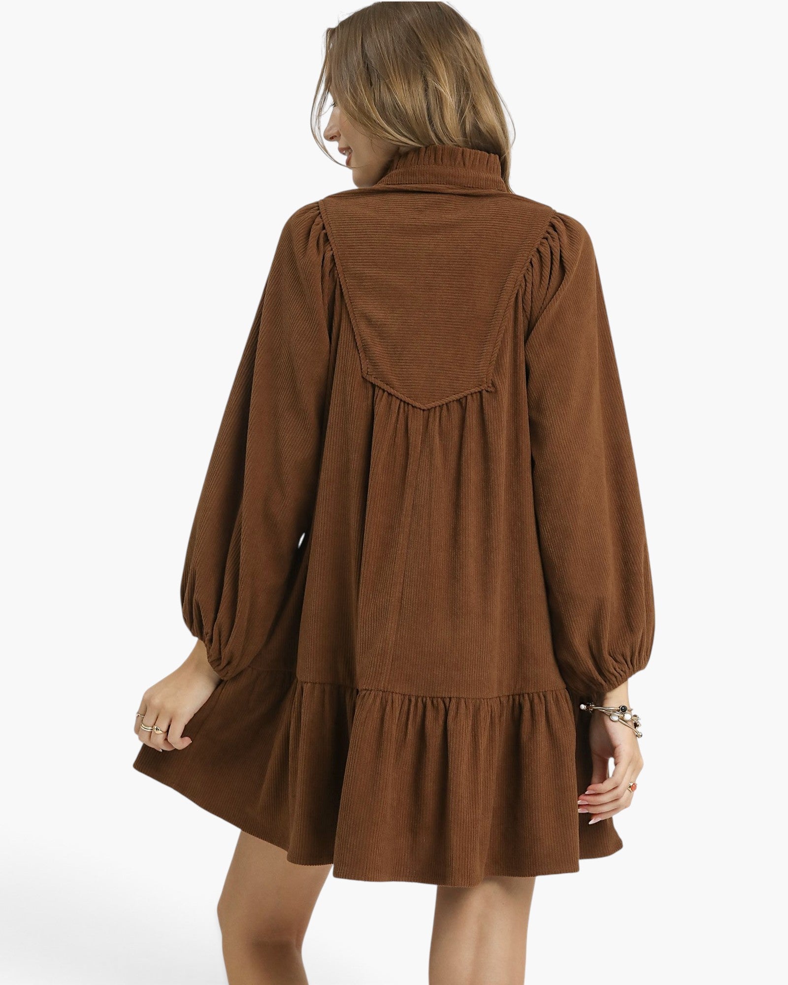 Back view of a Beach Rose Co. brown corduroy babydoll dress with balloon sleeves and a gathered yoke on a model.