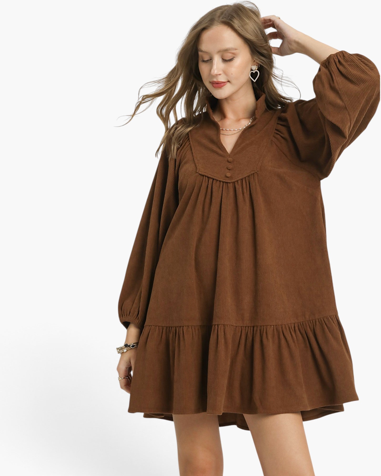 Beach Rose Co. brown corduroy babydoll dress with long balloon sleeves, split neckline, and ruffled hem on a model.