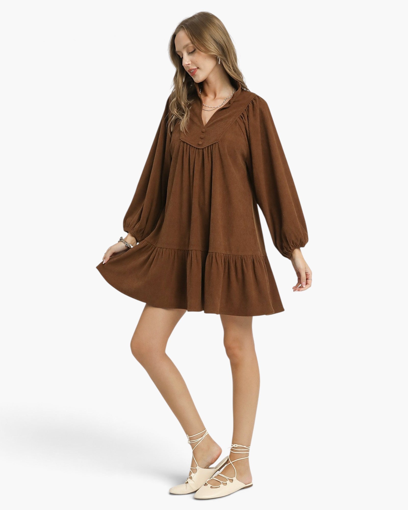 Beach Rose Co. brown corduroy babydoll dress with balloon sleeves, split neckline, and ruffled hem on a model