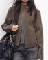 Beach Rose Co. brown faux leather moto jacket with a zip front, stand collar, and snap cuffs worn by a model.
