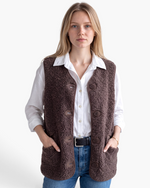 Beach Rose Co. brown polar fleece button-front vest with patch pockets worn over a white shirt and blue jeans.
