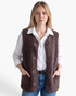Beach Rose Co. brown polar fleece button-front vest with patch pockets worn over a white shirt and blue jeans.