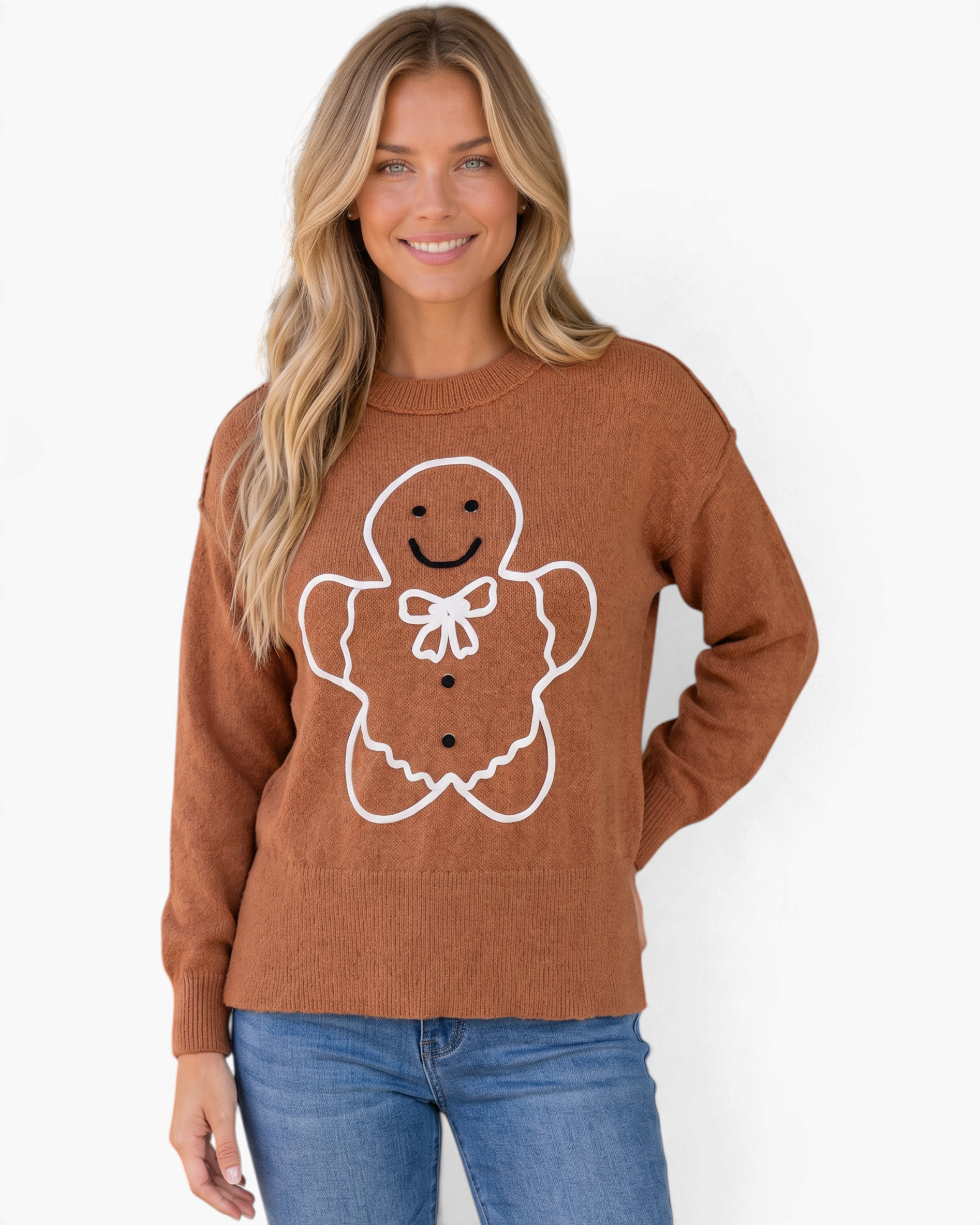Beach Rose Co. brown crewneck sweater featuring a smiling gingerbread man graphic with a white bow on a blonde model.
