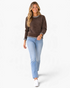 Beach Rose Co. brown textured knit sweater with gingham ruffle trim worn by a smiling woman with light blue jeans.