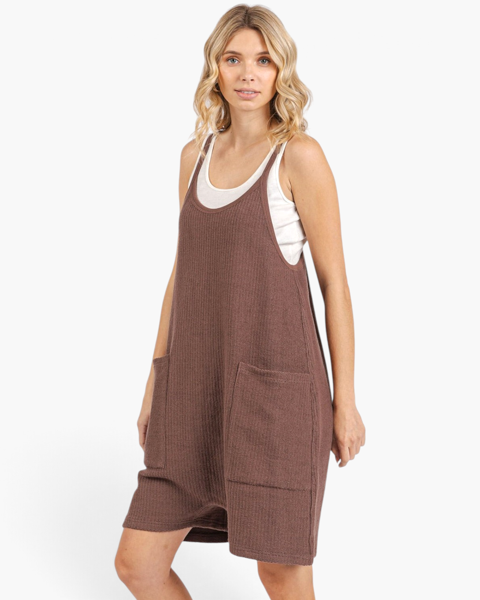 Beach Rose Co. brown sleeveless knit romper with wide legs, dropped crotch, and oversized pockets on a blonde model.