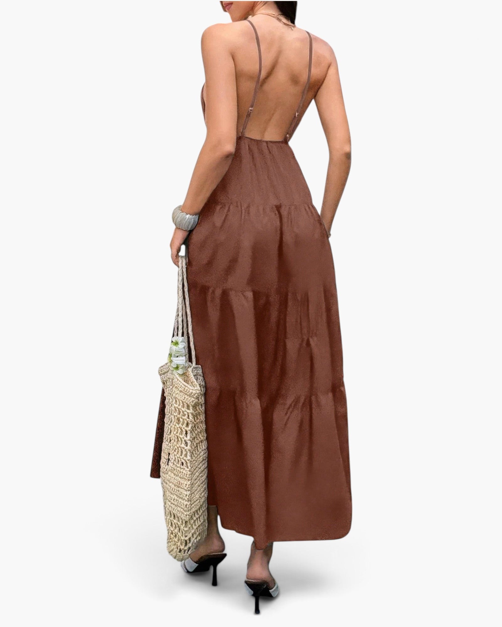 Beach Rose Co. brown sleeveless maxi dress with an open back and tiered skirt, worn with a woven tote bag.