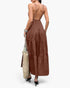 Beach Rose Co. brown sleeveless maxi dress with an open back and tiered skirt, worn with a woven tote bag.