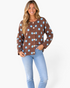 Beach Rose Co. brown cardigan with light blue polka dots, round neck, and button-front worn by a smiling model.