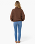 Beach Rose Co. brown pullover with white polka dots, pointed collar, and ribbed hem, worn with blue jeans, back view