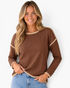 Beach Rose Co. brown long sleeve top with white polka dots, cream contrast trim, and dropped shoulders on a model.