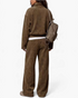 Beach Rose Co. brown ribbed two-piece set with a collared top and wide leg pants worn with a matching backpack