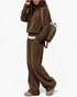 Beach Rose Co. brown ribbed two-piece set with collared long-sleeve top and wide-leg pants on a model with a backpack.