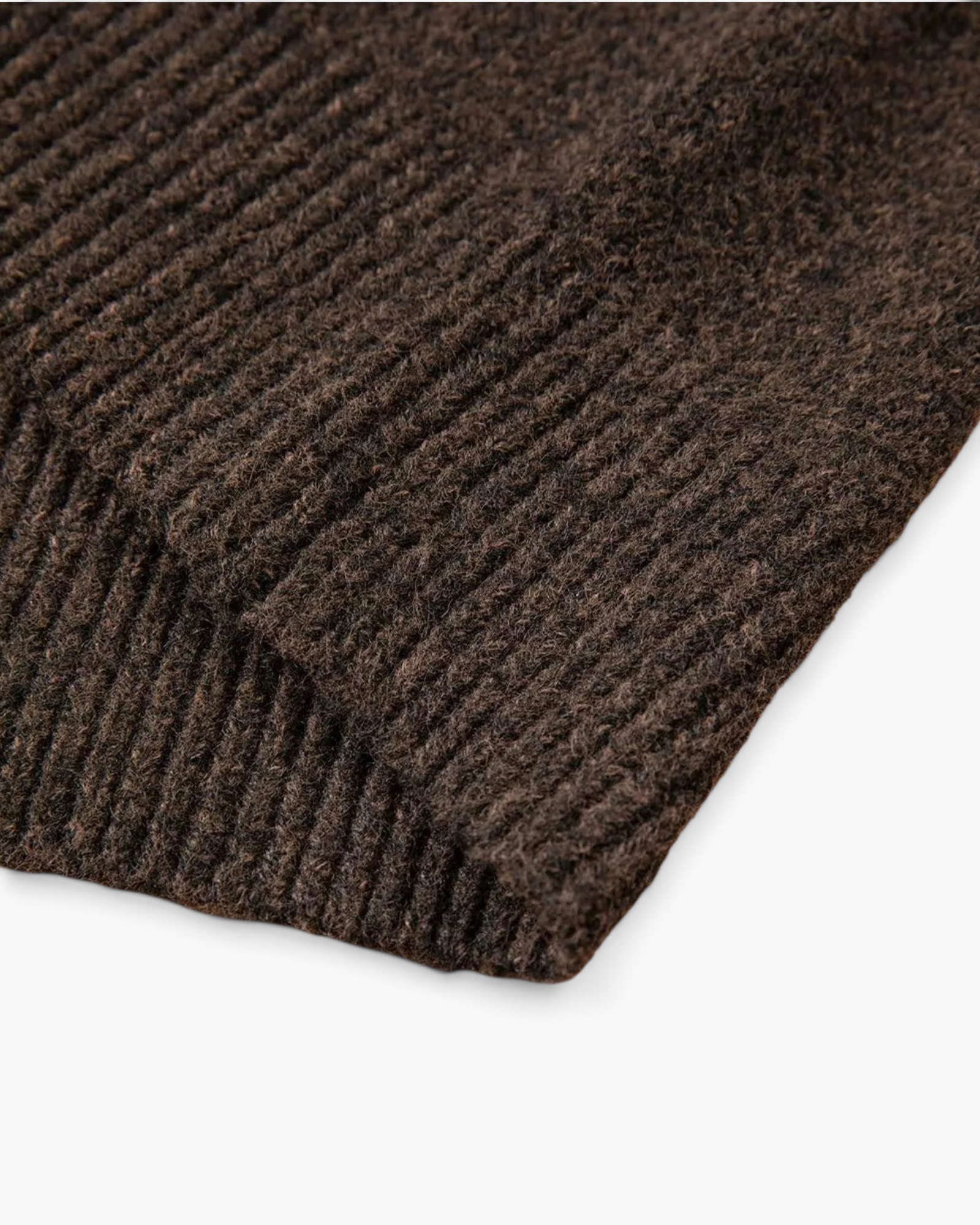 Close-up of the ribbed cuff and hem texture on a brown Beach Rose Co. knit sweater with subtle confetti flecks.