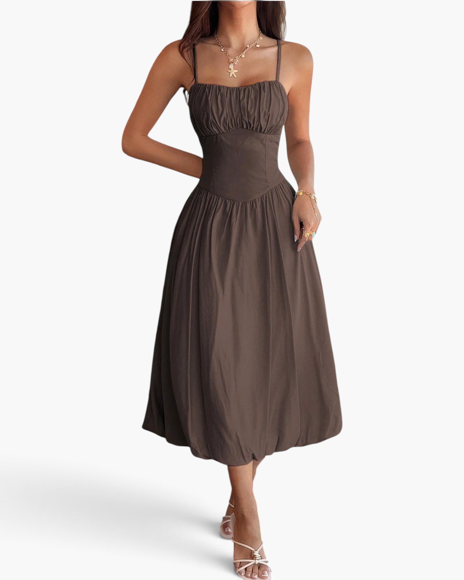 Beach Rose Co. brown sleeveless A-line dress with a ruched bust, worn by a woman with gold jewelry and strappy heels.