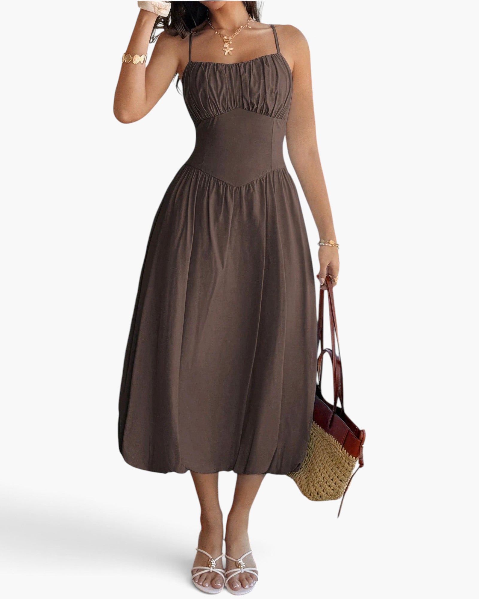 Beach Rose Co. brown sleeveless A-line midi dress with a ruched bust, worn by a model with a straw tote bag.