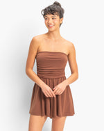 Beach Rose Co. brown strapless romper with shirred waist and relaxed shorts worn by a smiling model