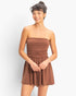 Beach Rose Co. brown strapless romper with shirred waist and relaxed shorts worn by a smiling model
