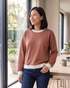 Beach Rose Co. brown crewneck sweatshirt with striped trim on the neckline, cuffs, and hem, worn by a smiling woman.