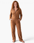 Beach Rose Co. brown velour zip-front jumpsuit with long sleeves, stand collar, and wide-leg silhouette.