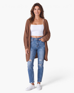 Beach Rose Co. brown waffle knit longline cardigan worn by a woman with a white tank top and distressed blue jeans.
