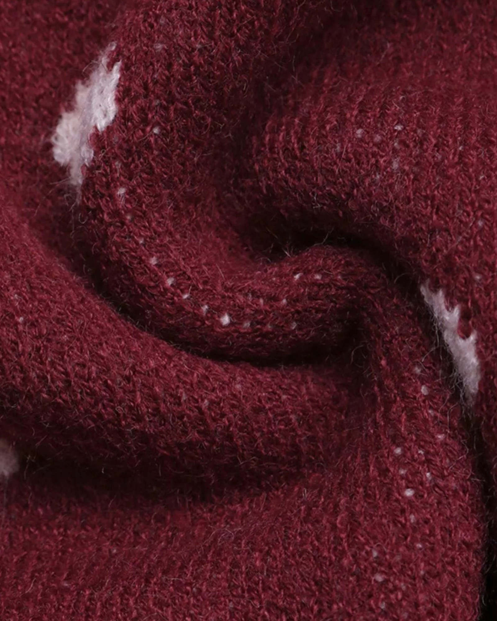 Close-up of the soft burgundy knit fabric with blush polka dots from Beach Rose Co. sweater