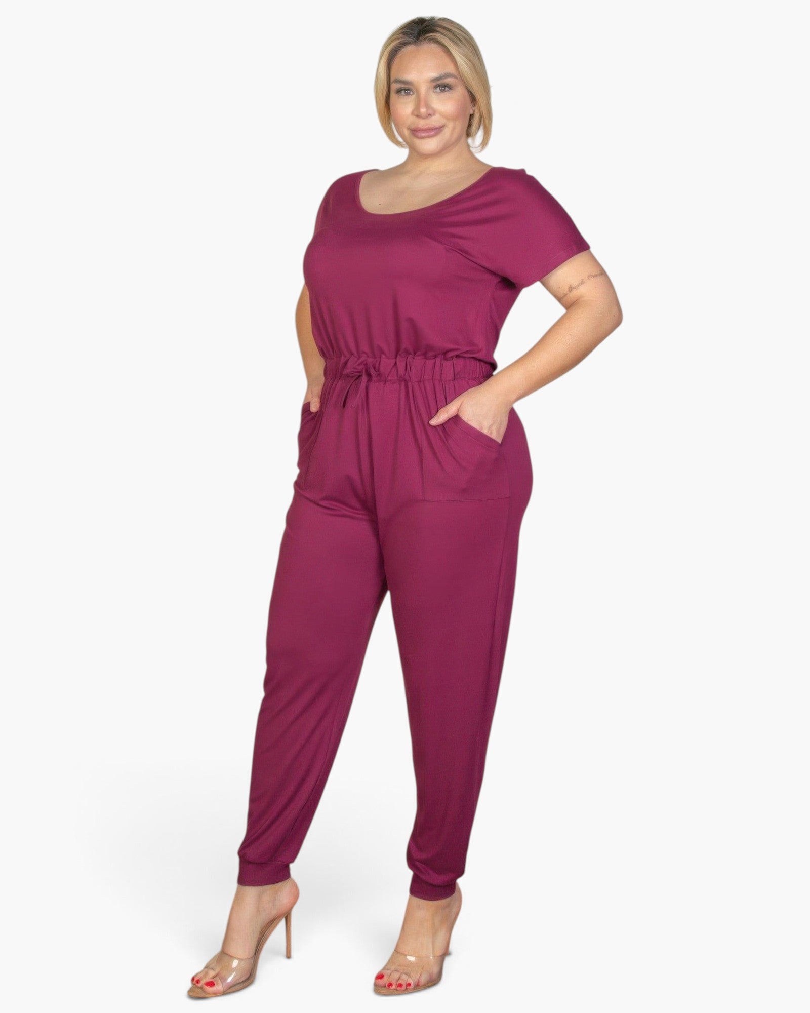 Beach Rose Co. plus size burgundy short sleeve jersey jumpsuit with a drawstring waist and pockets on a model