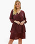 Beach Rose Co. plus size burgundy V-neck dress with a ruffled hem and long sleeves on a blonde model