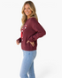 Beach Rose Co. burgundy crewneck sweater with sequin candy cane and bow detail worn by a smiling blonde woman