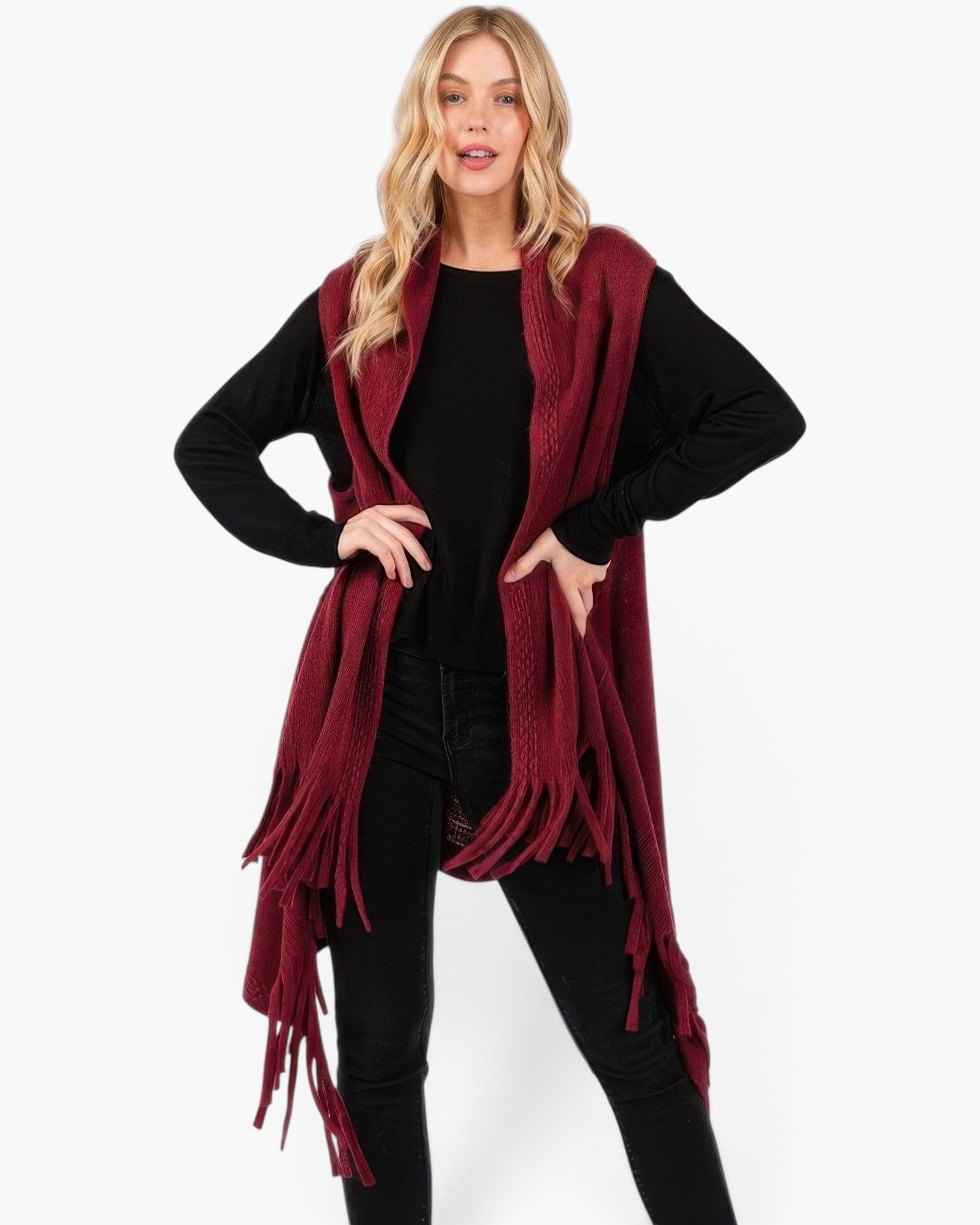 Beach Rose Co. model wearing a burgundy embossed dotted knit vest with tassel fringe over a black long sleeve top.