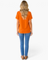 Beach Rose Co. burnt orange short sleeve tee worn by a blonde woman with blue jeans, back view
