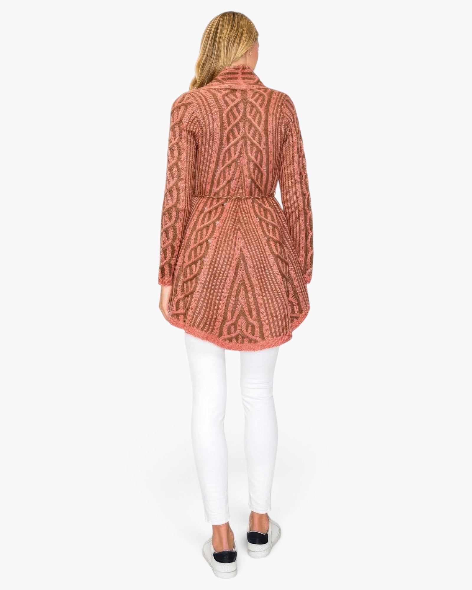 Beach Rose Co. open wool cardigan in pink and brown with intricate cable knit pattern, worn with white skinny jeans.