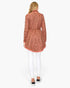 Beach Rose Co. open wool cardigan in pink and brown with intricate cable knit pattern, worn with white skinny jeans.
