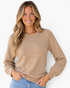 Beach Rose Co. camel raglan knit sweater with button-cuff details and ribbed crewneck worn by a smiling woman.