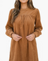 Beach Rose Co. camel corduroy mini dress with puff sleeves and gathered yoke detail on a model