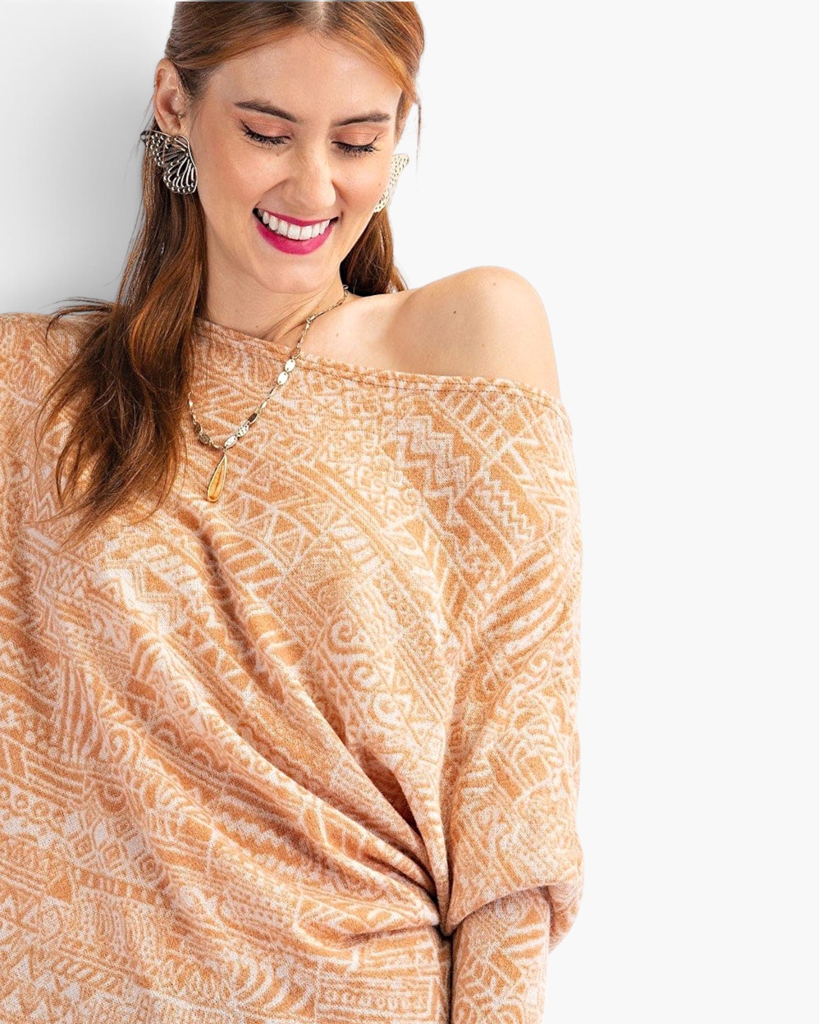 Beach Rose Co. camel knit top with tribal print, asymmetrical neckline, and relaxed dolman sleeves on a smiling model.
