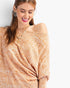 Beach Rose Co. camel knit top with tribal print, asymmetrical neckline, and relaxed dolman sleeves on a smiling model.