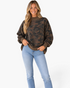 Beach Rose Co. relaxed camo sweatshirt with a ribbed mock neck and brown trim worn by a smiling blonde woman.